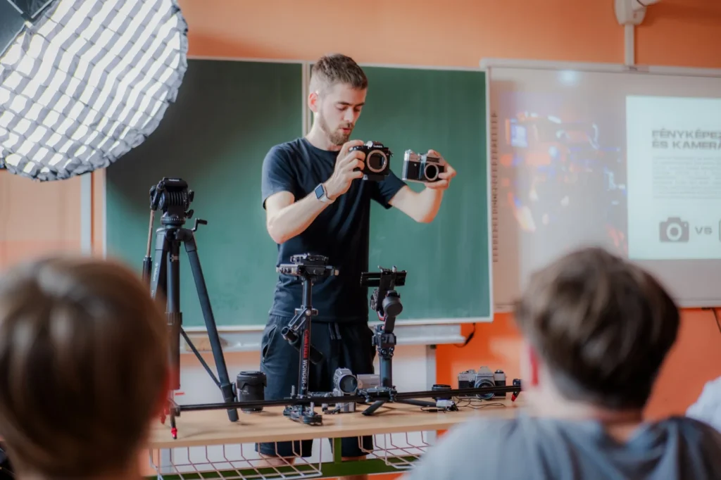 Lektor ZAGX Lectures ukazuje žiakom fotoaparáty a filmovú techniku v triede